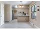 Bright kitchen and dining area with white tiled floors, ample storage space, and stainless steel appliances at 10851 E Iliff Pl, Aurora, CO 80014