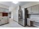 Spacious kitchen featuring stainless steel refrigerator, white cabinetry and marble floors at 10851 E Iliff Pl, Aurora, CO 80014