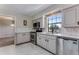 Well-lit kitchen with white cabinets, stainless steel appliances, and marble floors at 10851 E Iliff Pl, Aurora, CO 80014