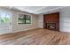 Spacious living room featuring hardwood flooring, a brick fireplace, and plenty of natural light at 10851 E Iliff Pl, Aurora, CO 80014