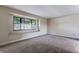 Living room boasts a large window with a cushioned window seat, complemented by neutral-colored walls and plush carpeting at 10851 E Iliff Pl, Aurora, CO 80014