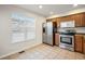 Well-lit kitchen with stainless steel appliances, light tile floor and a window at 23465 E Platte Dr # B, Aurora, CO 80016