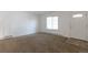 Bright living room featuring neutral carpet, white walls, and a large window offering plenty of natural light at 3577 S Ouray Cir, Aurora, CO 80013