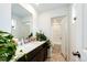 Bright bathroom with a modern vanity, decorative plants, and doorway to an adjacent shower at 947 W Beverly St, Elizabeth, CO 80107