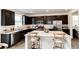 Open kitchen with dark cabinets, stainless steel appliances, and spacious white countertop island at 947 W Beverly St, Elizabeth, CO 80107