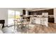 Stylish kitchen featuring a dining area, dark cabinets, and stainless steel appliances at 947 W Beverly St, Elizabeth, CO 80107