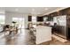 Modern kitchen with dark cabinets, stainless steel appliances, and large island with counter seating at 947 W Beverly St, Elizabeth, CO 80107