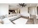 Open living space with a large sectional sofa that flows into an open kitchen, hardwood floors, and staircase at 947 W Beverly St, Elizabeth, CO 80107