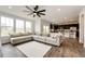 Open floor plan featuring living room with hardwood floors, large sectional sofa, and bright kitchen with a breakfast bar at 947 W Beverly St, Elizabeth, CO 80107