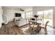 Bright living room boasts wood floors, a large sectional sofa, and a dining area by sliding glass doors at 947 W Beverly St, Elizabeth, CO 80107