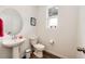 Well-lit powder room with pedestal sink, modern fixtures, and a clean design at 947 W Beverly St, Elizabeth, CO 80107