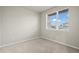 Bright, carpeted bedroom with a large window offering ample natural light and neutral wall paint throughout at 479 Interlocken Blvd # 105, Broomfield, CO 80021