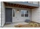 Inviting townhome entrance featuring a gray front door, a window with blinds, and an exterior air conditioning unit at 479 Interlocken Blvd # 105, Broomfield, CO 80021
