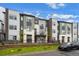 Modern townhome showcasing diverse exterior finishes, landscaping, and a parked car in front of the property at 479 Interlocken Blvd # 105, Broomfield, CO 80021
