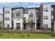 Modern townhome exterior featuring varied textures, landscaping, and a well-maintained front yard with a black metal fence at 479 Interlocken Blvd # 105, Broomfield, CO 80021