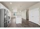 Modern kitchen with stainless steel appliances, white cabinets, an island with bar seating, and hardwood flooring at 479 Interlocken Blvd # 105, Broomfield, CO 80021