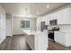 Bright kitchen features white cabinets, stainless steel appliances, and a large center island with hardwood floors at 479 Interlocken Blvd # 105, Broomfield, CO 80021