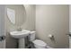 Cozy powder room features a pedestal sink, round mirror, and neutral decor at 479 Interlocken Blvd # 105, Broomfield, CO 80021