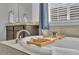 Relaxing soaking tub with a wooden tray, luxurious bath products, and natural light at 23913 E Swallow Cir, Aurora, CO 80016
