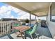 Covered deck featuring a wooden table, green chairs, and a grill at 23913 E Swallow Cir, Aurora, CO 80016