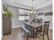 Elegant dining room with tray ceiling, hardwood floors, and a modern chandelier at 23913 E Swallow Cir, Aurora, CO 80016