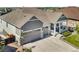 Gray two-story home featuring a three car garage and covered porch at 23913 E Swallow Cir, Aurora, CO 80016