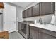 Functional laundry room with gray cabinets, sink, countertop, and modern washer and dryer at 23913 E Swallow Cir, Aurora, CO 80016