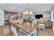 Open-concept kitchen, dining, and living area with hardwood floors and modern lighting fixtures at 23913 E Swallow Cir, Aurora, CO 80016