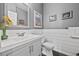 Bright bathroom featuring a modern vanity, toilet, decorative shiplap, and stylish decor at 8532 W Eden Dr, Littleton, CO 80127