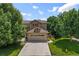 Charming two-story home featuring a stone-accented garage and a well-manicured front lawn with mature trees at 8532 W Eden Dr, Littleton, CO 80127
