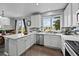 Bright kitchen featuring white cabinetry, stainless steel appliances, and a stylish backsplash, complemented by hardwood floors at 8532 W Eden Dr, Littleton, CO 80127