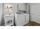 Functional laundry room with modern washer, dryer, utility sink, and ample storage cabinets at 8532 W Eden Dr, Littleton, CO 80127