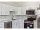Bright kitchen featuring stainless steel appliances, white cabinets, and quartz countertops at 2340 Geneva, Aurora, CO 80010