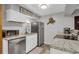 Compact kitchen features stainless steel appliances, light countertops, and white cabinets at 1611 Garfield Ave # 2, Louisville, CO 80027