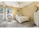 Cozy bedroom with a white iron bed frame, soft textures, and a view from the window at 7780 W 87Th Dr # E, Arvada, CO 80005