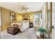 Cozy bedroom featuring neutral colors, a ceiling fan, and a decorative trunk at the foot of the bed at 7780 W 87Th Dr # E, Arvada, CO 80005