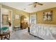 Bedroom showcasing an antique wooden dresser with a mirror, leading to a seating area at 7780 W 87Th Dr # E, Arvada, CO 80005