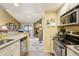 Well-lit kitchen with granite counters, tile backsplash, and an adjacent open living area at 7780 W 87Th Dr # E, Arvada, CO 80005