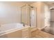 Bathroom featuring a soaking tub and glass enclosed shower at 10037 Idalia St, Commerce City, CO 80022