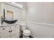 Stylish powder room featuring a vessel sink, decorative vanity, and modern toilet at 10037 Idalia St, Commerce City, CO 80022