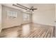 Bright bedroom featuring a trey ceiling with ceiling fan and hardwood floors at 10037 Idalia St, Commerce City, CO 80022
