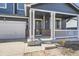 Inviting covered porch with brick accents, white pillars, and a view of the front yard at 10037 Idalia St, Commerce City, CO 80022