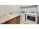 Functional laundry room with wooden cabinets, sink, and a modern washer and dryer at 10037 Idalia St, Commerce City, CO 80022