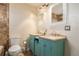 Bathroom features double sinks, turquoise cabinets, and travertine tile at 1277 W 135Th Pl, Broomfield, CO 80234