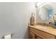 Powder room features a granite countertop, oval mirror, and floral accents at 1277 W 135Th Pl, Broomfield, CO 80234