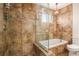 Modern bathroom featuring a glass-enclosed shower over a tub and brown tile at 1277 W 135Th Pl, Broomfield, CO 80234