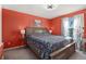 Cozy bedroom with vibrant coral walls, complemented by floral bedding and natural light at 1277 W 135Th Pl, Broomfield, CO 80234