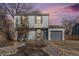 Charming two-story home with gray siding, a one-car garage, and xeriscaped front yard at dusk at 1277 W 135Th Pl, Broomfield, CO 80234