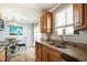 Kitchen featuring granite countertops, wood cabinets, stainless sink, and view into the dining room at 1277 W 135Th Pl, Broomfield, CO 80234