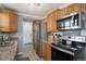 Modern kitchen features stainless steel appliances, wood cabinets, and granite countertops at 1277 W 135Th Pl, Broomfield, CO 80234